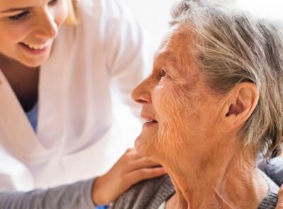 afbeelding van een zorgprofessional met een oudere patiënte