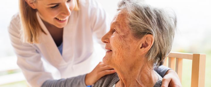 afbeelding van een zorgprofessional met een oudere patiënte